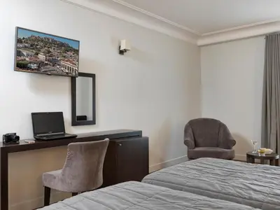 a bedroom with a bed and a desk and a chair at Acropolis Hill Hotel in Athens