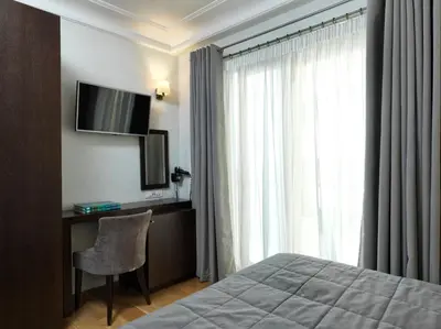 a hotel room with a bed and a desk and a television at Acropolis Hill Hotel in Athens