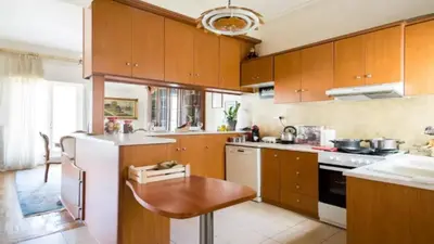 a kitchen with wooden cabinets and a white refrigerator at Large 3 bedroom Apt with Terrace in Athens