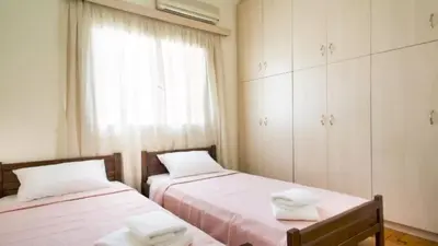 two beds in a small room with a window at Large 3 bedroom Apt with Terrace in Athens