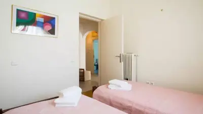 a room with two beds with pink sheets at Large 3 bedroom Apt with Terrace in Athens