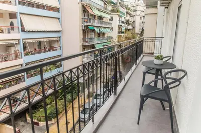 a balcony with a table and a chair at Olympus Residence in Athens
