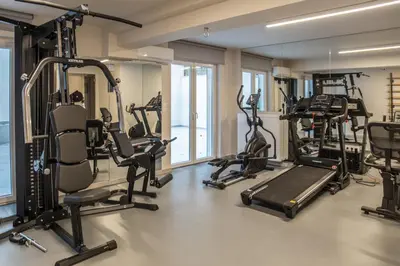 a gym with treadmills and ellipticals in a building at Olympus Residence in Athens
