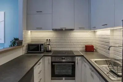 a kitchen with white cabinets and a stove top oven at Olympus Residence in Athens
