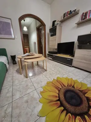 a living room with a table and a sunflower on the floor at •Budget travellers •Great location in Athens