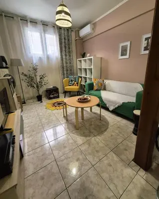 a living room with a green couch and a table at •Budget travellers •Great location in Athens