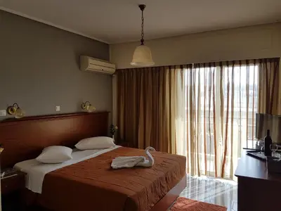 a hotel room with a bed and a large window at Apollo Hotel in Athens