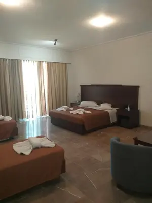 a hotel room with two beds and a couch at Apollo Hotel in Athens