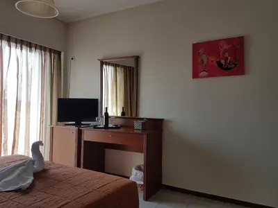 a bedroom with a desk with a computer and a mirror at Apollo Hotel in Athens