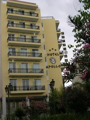 a yellow building with a clock on the side of it at Apollo Hotel in Athens