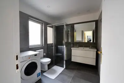 a bathroom with a toilet sink and a washing machine at Athens Squared Apartments in Athens