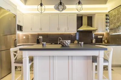a kitchen with white cabinets and a blue counter top at Comfortable and Spacious 2 bdr Apt in Athens