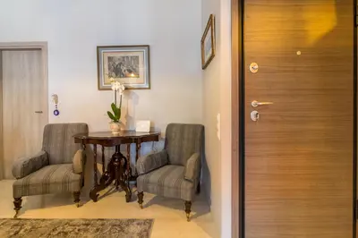 a hallway with a table and two chairs and a door at Comfortable and Spacious 2 bdr Apt in Athens