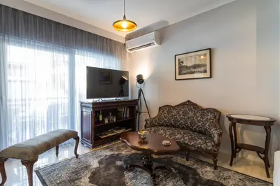 a living room with a couch and a television at Comfortable and Spacious 2 bdr Apt in Athens