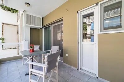 a small balcony with a table and chairs in a room at Comfortable and Spacious 2 bdr Apt in Athens