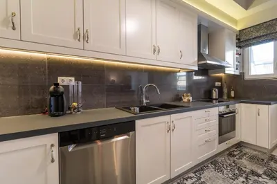 a kitchen with white cabinets and a sink at Comfortable and Spacious 2 bdr Apt in Athens