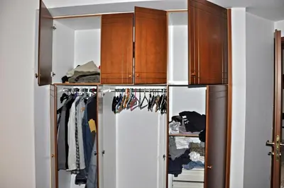 a walk in closet with wooden cabinets at Seaside Apartment 157 м2 in Athens