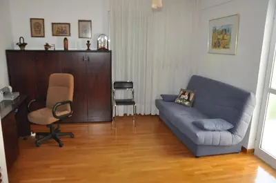 a living room with a blue couch and a chair at Seaside Apartment 157 м2 in Athens
