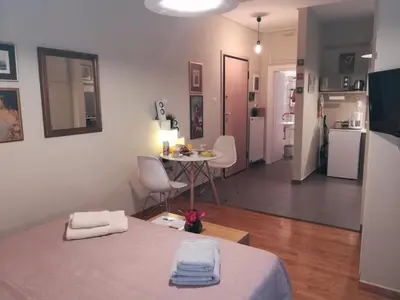 a room with a bed and a table and a kitchen at Koukaki ideal studio for 2 in Athens
