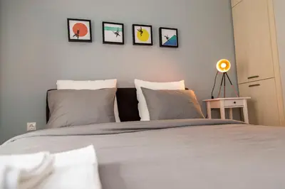 a bedroom with a bed with four pictures on the wall at Gazi Discrit Next To Subway in Athens