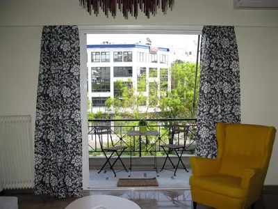 a living room with a yellow chair and a window at ELITE apartment 5 min to Acropolis in Athens