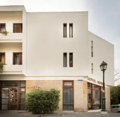 a white building with a street light in front of it at Nefeli Hotel in Athens