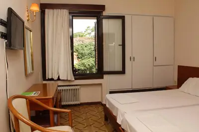 a bedroom with a bed and a desk and a window at Nefeli Hotel in Athens