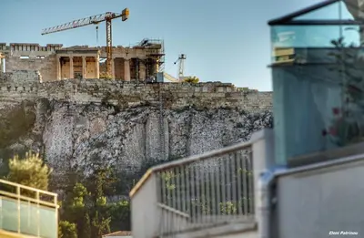 a building on the side of a mountain with a crane at Dreamin Athens - Monastiraki Apartments in Athens