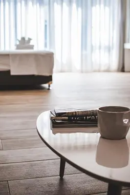 a coffee table with a book and a cup on it at Dreamin Athens - Monastiraki Apartments in Athens