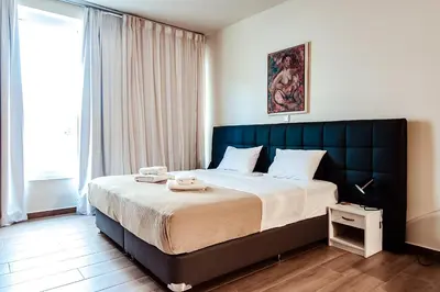 a bedroom with a large bed with a blue headboard at Dreamin Athens - Monastiraki Apartments in Athens