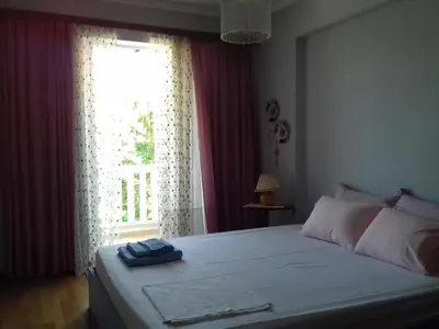 a bedroom with a large bed with a window at Blue Sky appartment in Pallíni