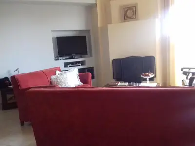a living room with a red couch and a tv at Blue Sky appartment in Pallíni