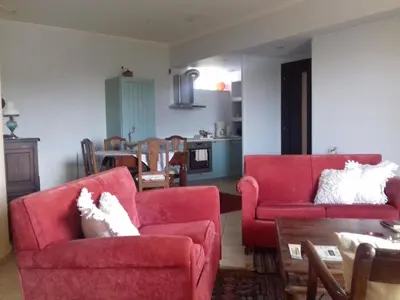 a living room with two red chairs and a table at Blue Sky appartment in Pallíni