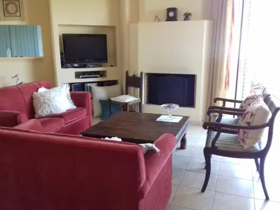 a living room with a red couch and a table at Blue Sky appartment in Pallíni