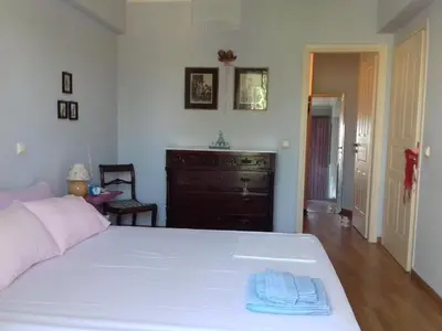 a bedroom with a white bed and a dresser at Blue Sky appartment in Pallíni