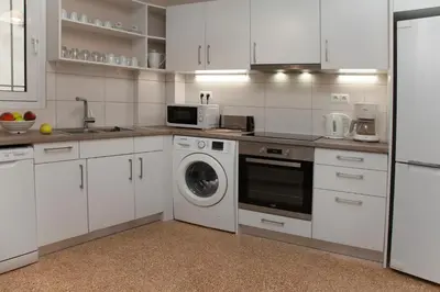 a kitchen with white cabinets and a washing machine at Leonidas Loft in the heart of Athens by GHH in Athens