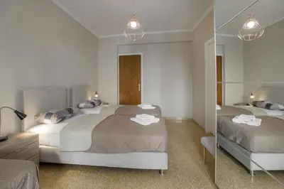 a bedroom with two beds and a mirror at Leonidas Loft in the heart of Athens by GHH in Athens