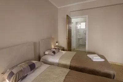 two beds in a small room with a bathroom at Leonidas Loft in the heart of Athens by GHH in Athens