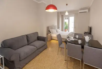 a living room with a couch and a table at Leonidas Loft in the heart of Athens by GHH in Athens