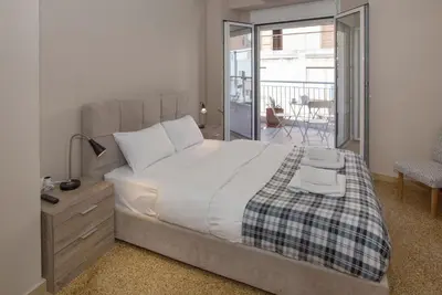 a bedroom with a large bed and a balcony at Leonidas Loft in the heart of Athens by GHH in Athens