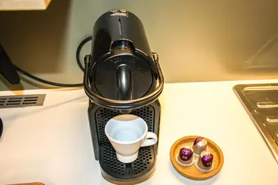 a black blender sitting on a counter with a cup of coffee at Dynasta Central Suites in Athens