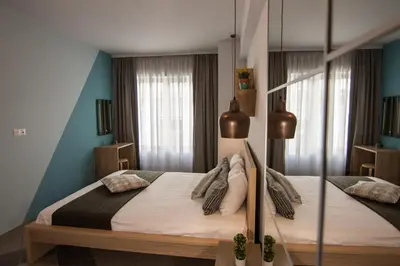 a bedroom with a large bed with white sheets and pillows at Dynasta Central Suites in Athens