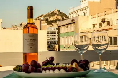 a plate of fruit and two wine glasses on a table at Dynasta Central Suites in Athens