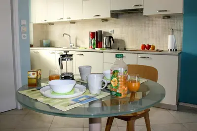 a glass table in a kitchen with a bottle of orange juice at Dynasta Central Suites in Athens