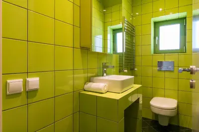 a yellow bathroom with a sink and a toilet at Athens Mosaico Suites & Apartments in Athens