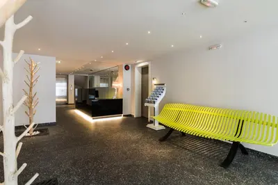 a yellow bench in a room with a staircase at Athens Mosaico Suites & Apartments in Athens