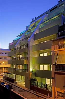 an apartment building with balconies at night at Athens Mosaico Suites & Apartments in Athens