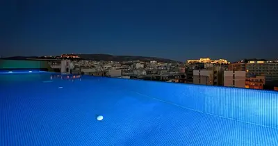 a large blue swimming pool on top of a building at Athens Mosaico Suites & Apartments in Athens