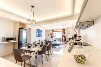 a kitchen and living room with a table and chairs at Leo - Unique Glyfada Apartment in Athens