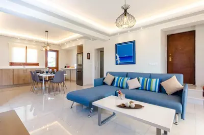 a living room with a blue couch and a table at Leo - Unique Glyfada Apartment in Athens